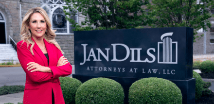 woman standing in front of jandils attorneys company banner